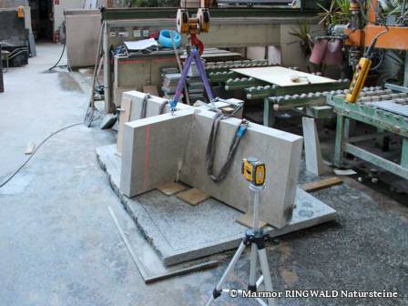 Per Laser wird das Sockelkreuz in der Werkhalle endausgerichtet.