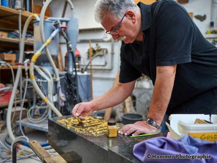 Alexander Ringwald bei der Vergoldung einer Inschrift.